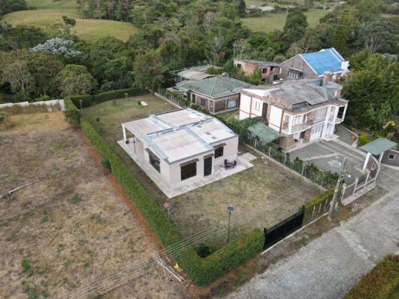 Vista aérea de la casa rodeada de colinas verdes